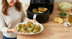 Golden brown roasted cabbage wedges on a white platter garnished with fresh cilantro and lemon juice